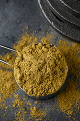 Scoop of Hemp Vegan protein powder on dark rustic background. Sport nutrition.