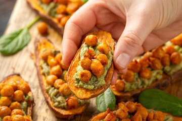 Sweet potato toast loaded with avocado guacamole and baked chickpeas sprinkled with chili flakes...