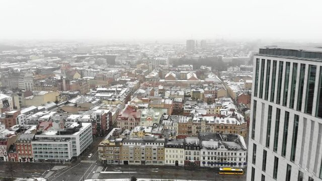 Drone flying straight forward over Malm&ouml; beside Clarion hotel while it is snowing.