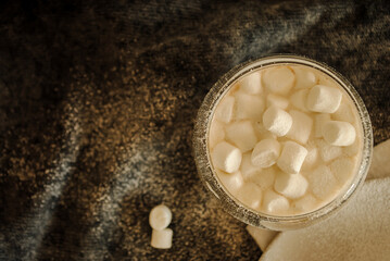 Cocoa with milk and marshmallows in a glass glass.