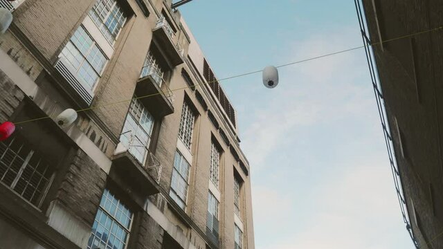 Chinese lamps dangling in the wind between houses in Chinatown, London.