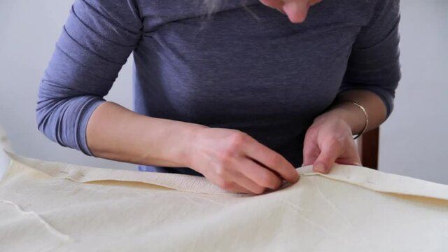 woman hand sewing with needle and thread in a factory on a table stock video