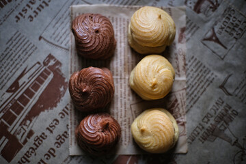 Two-color Eclair, placed on cooking paper, delicious dessert in leisure time.