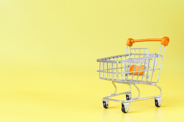 Orange empty metal basket on yellow background close-up trading concept