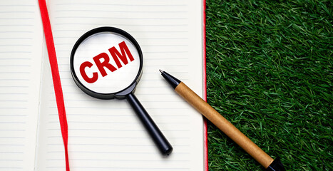 Word CRM - customer relationship management written on notebook red letters