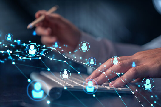 Hands of hr specialist is typing the keyboard in the internet to find the best candidates to create international network in recruitment process. Formal wear. Social media hologram icons.