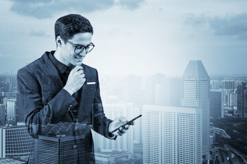 Young handsome businessman in suit and glasses using phone and thinking how to tackle the problem, new career opportunities, MBA. Singapore on background. Double exposure.