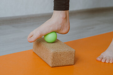 Foot on massage ball for plantar fascia massage and hydration. Concept: self care practices at home