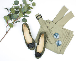 Green women's shoes and overalls on a white background with leaves.