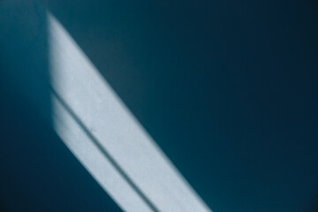 diagonal shadow and rays of light on a blue wall. shadows for natural light effects