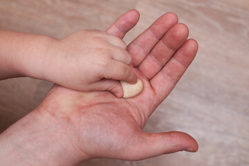 The little son puts a small plaster heart in his dad's hand.
