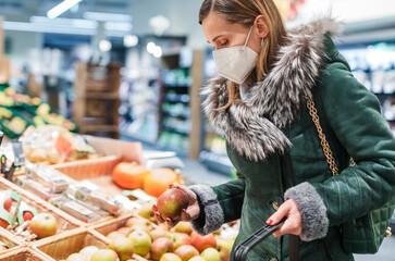 Woman wearing ffp2 face mask shopping in supermarket