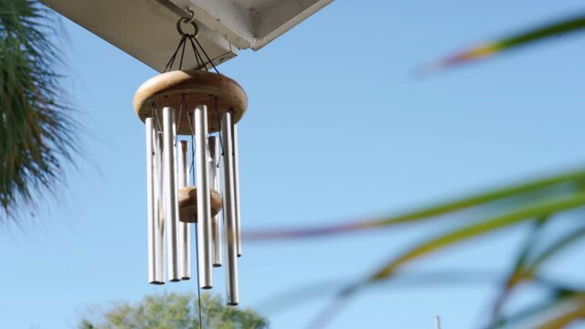Calming and relaxing view of a wind chime blowing in a tropical garden