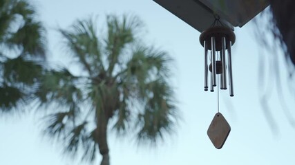 Calming and relaxing view of a wind chime blowing in a tropical garden