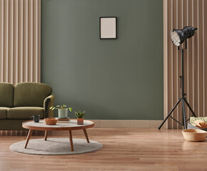 Green living room wall background with grey decorative chair, lamp frame middle table and poster...