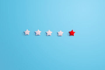 Row of five paper star review with red one on blue background. customer satisfaction, Top product rating, business leadership concept.