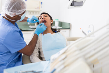Portrait of female patient during dental checkup in modern dentist office. Health care and oral hygiene concept