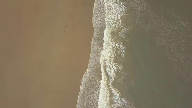 Aerial birds eye view drone footage of waves crashing onto the beach, Seaburn Beach, Sunderland.
