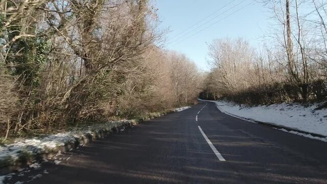 Driving fast along snowy white rural snow covered secluded countryside road wilderness POV