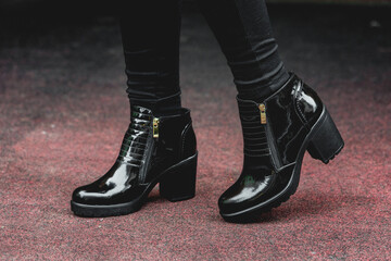Women's black patent leather boots. Street photo. Fashion advertising shoes photos.