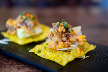Fried squid and salted egg served on fried dumplings