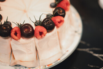 Taking of delicious cake cream rose decoration with raspberries and berries