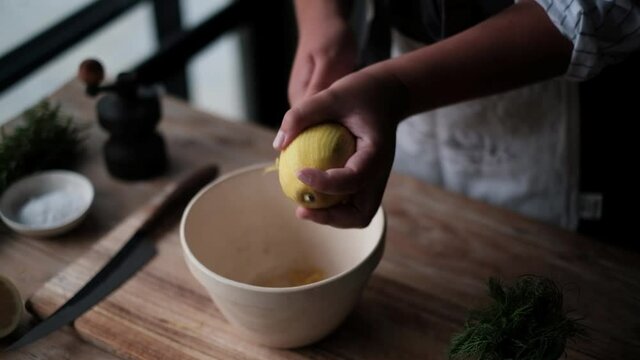 Zesting a lemon by hand in a moody setting.