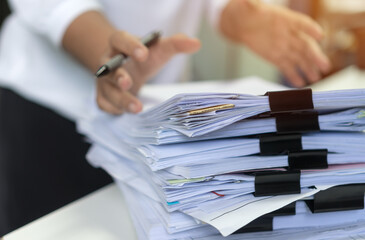 Employee woman hands checking Business unfinished Documents  with stacks paper files and searching...