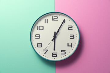 Fototapeta na wymiar Retro clock on pink and green table background, vintage style and lifestyle concept