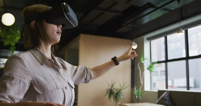 Asian businesswoman standing using vr googles in a modern office