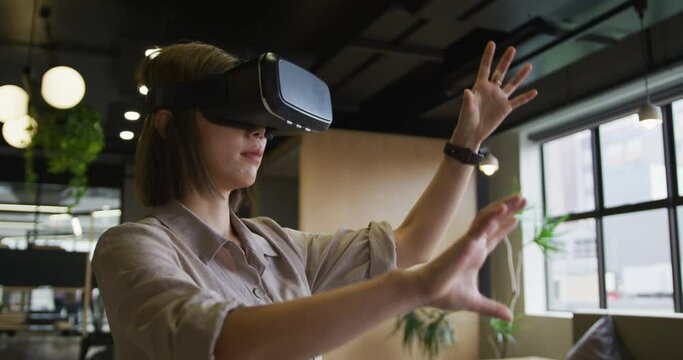 Asian businesswoman standing using vr googles in a modern office