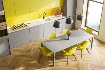 Gray and yellow kitchen corner with table and windows, top view