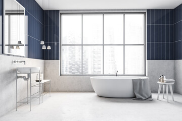 White and blue bathroom with bathtub, sink with mirror and window