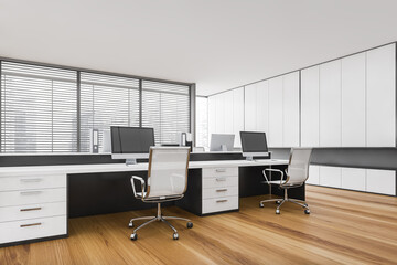 Naklejka premium White office room with tables and computers, armchairs on parquet floor