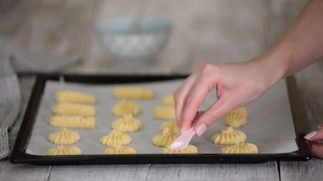 Female hands a making homemade biscuit shortbread cookies.