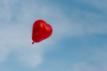 heart shaped flying balloon in the blue sky