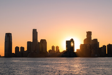 Fototapeta na wymiar Jersey City New Jersey Skyline Silhouette during a Bright Sunset along the Hudson River