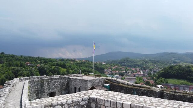 View over Tešanj Castle in Bosnia & Herzegovina with waving flag - Pan from right to left