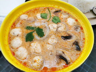 Top view of thai soup tom yam in a yellow plate and ingredients