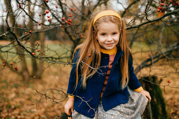 A young cute girl posing in autumn park