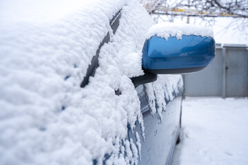 a lot of snow on a blue car close up