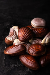 Belgian chocolate seashells on a black table