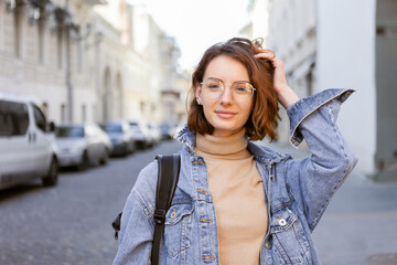 Stylish attractive woman in denim jacket on urban street