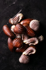 Belgian chocolate seashells on a black table