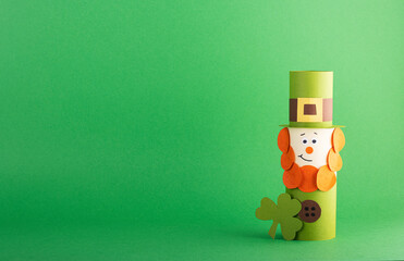 Green cute Leprechaun made of handmade paper on a green background, space for text