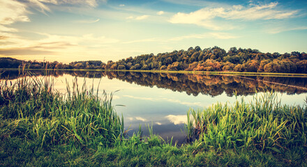 Jezioro o zachodzie słońca. Wiejskie krajobrazy wiejskie w Polsce