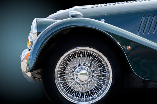 Boxtel Netherlands - september 22 2019: Side view of a classic Morgan car with shiny spokes isolated on a blue and grey background