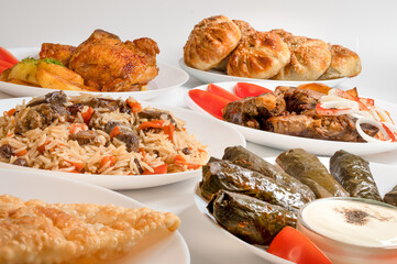 Kazan kabob, Plov, Dolma and fried chicken. Uzbek Main dishes on white plates. 