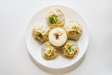 Top view of manti with lamb meat. Delicious uzbek dumplings on a white plate.