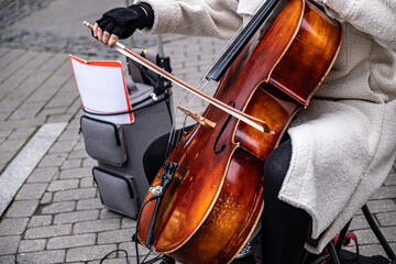 A street musician makes money for lunch. The musician plays in the street.